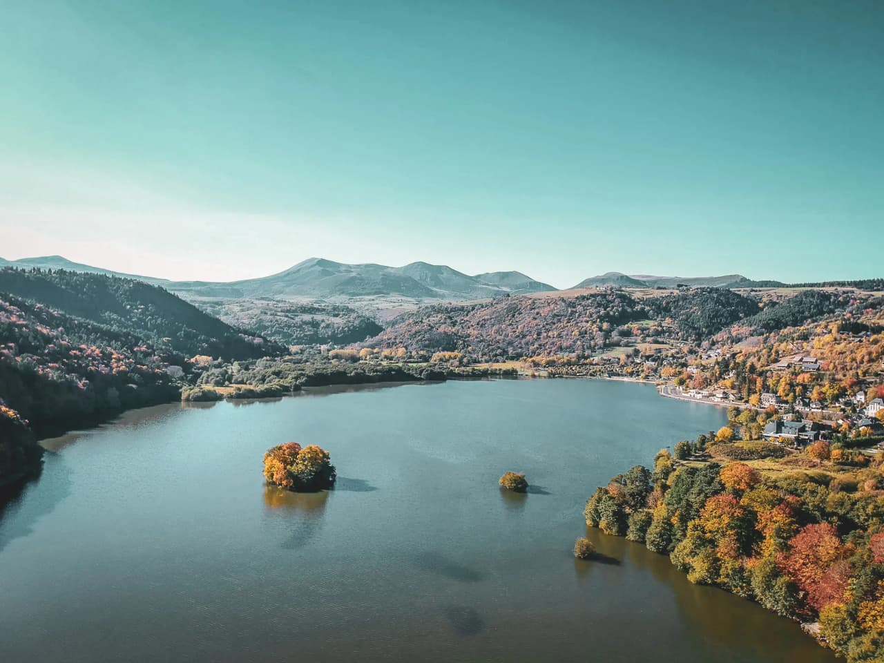 "Vredig meer omringd door kleurrijke heuvels, uitnodigend om te wandelen en te zwemmen."