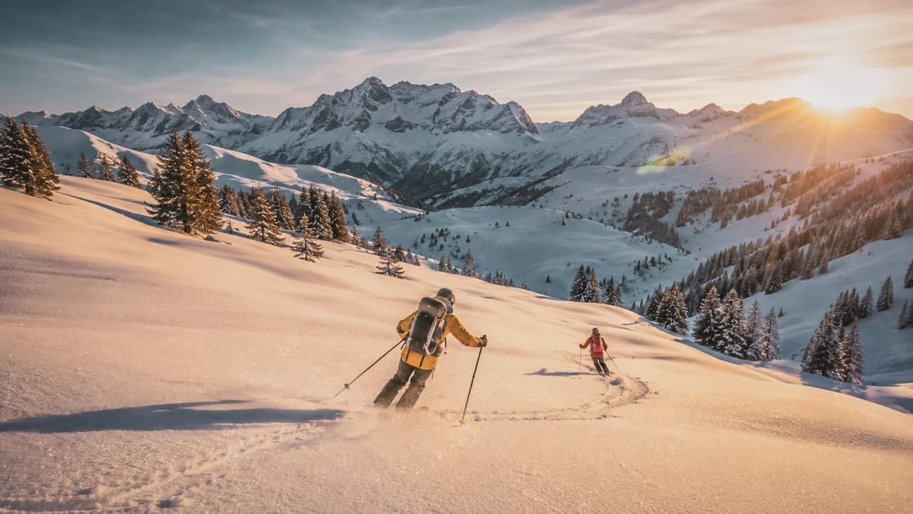 Hikers skiing through a magical alpine landscape, bathed in the light of the setting sun.