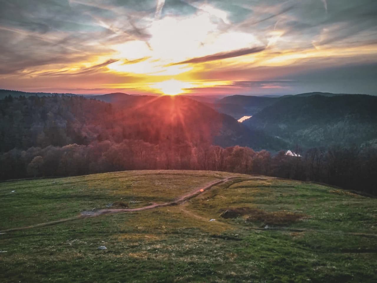 Sunset over the Vosges, lush green mountains and paths that invite adventure.