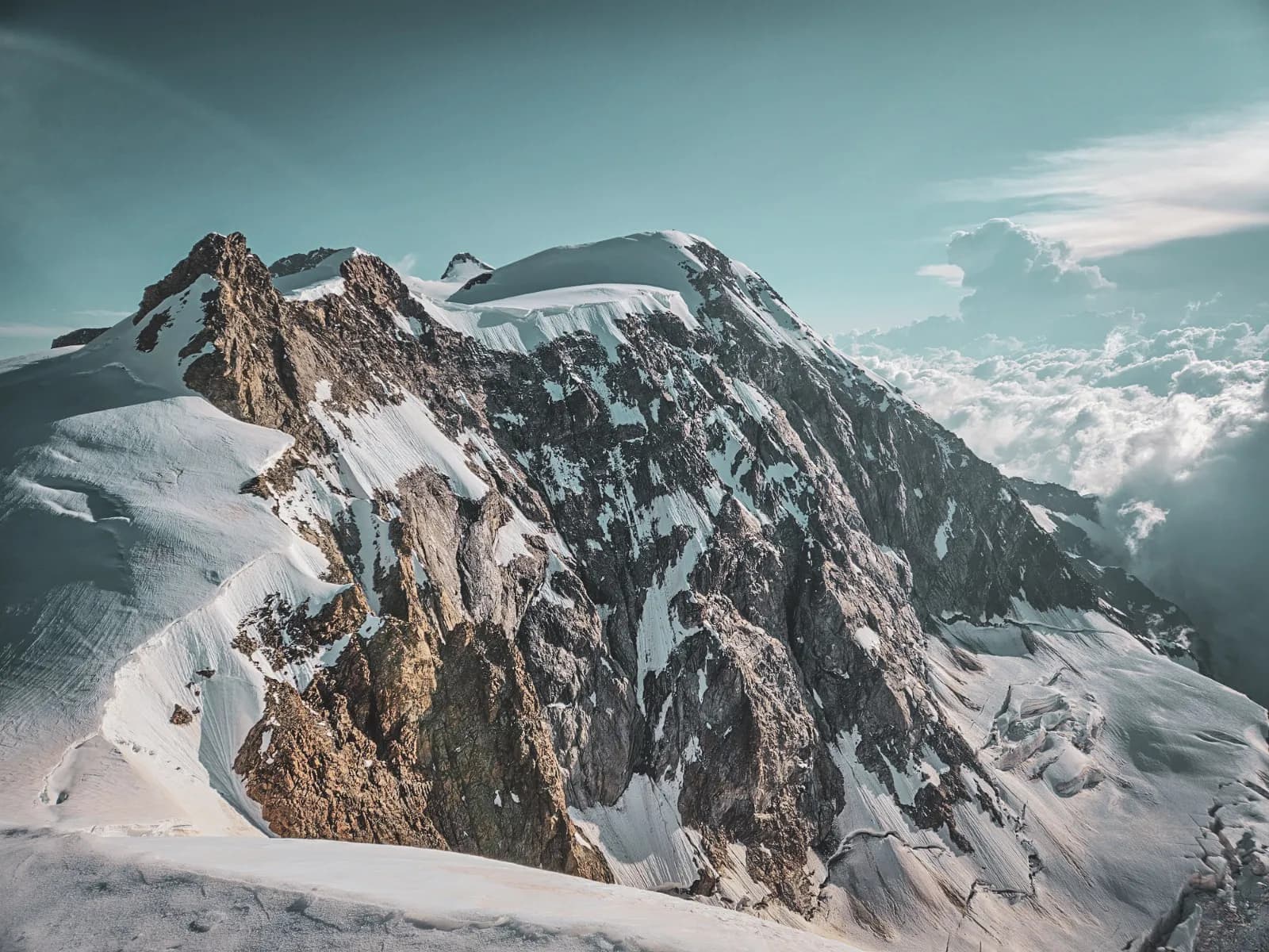 Majestic snow-capped mountains towering above a serene blue sky.