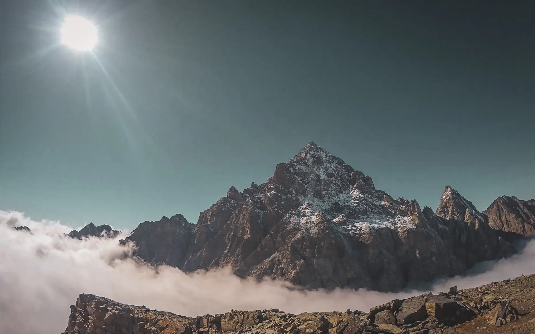 Mont Viso majestueux sous un ciel bleu, domine des nuages, invitant à l'aventure alpine.