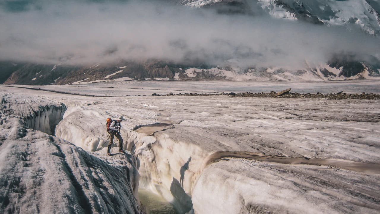 Un randonneur sur le glacier d'Aletsch, face à des paysages époustouflants et des crevasses majestueuses.