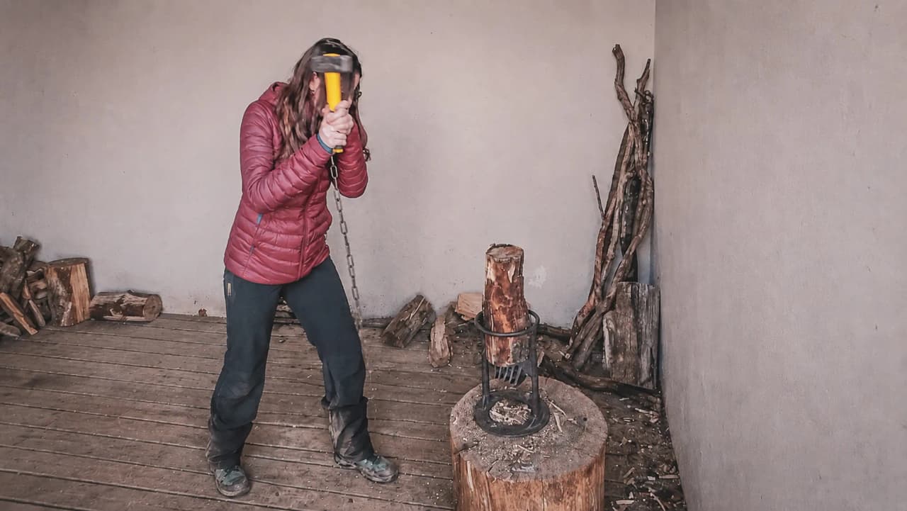 Femme en pleine nature, attaquant un morceau de bois dans une cabane chaleureuse du Vercors.