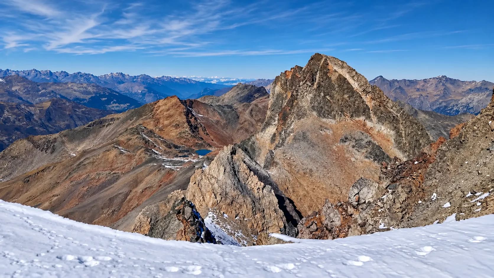 A spectacular panoramic view of the rocky peaks and high-altitude lakes beneath a clear sky.