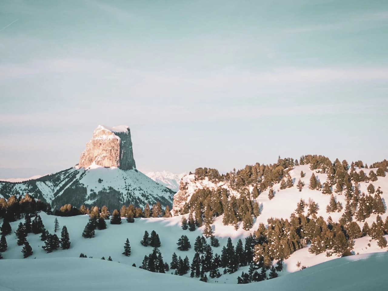 Een besneeuwde berg met groene bomen, die een majestueus uitzicht biedt op het ruige landschap.