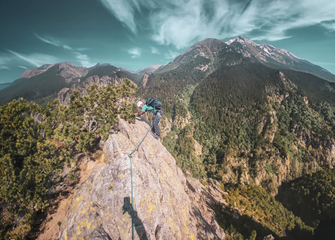 Alpiniste sur une arête des Pyrénées, panorama montagneux à couper le souffle.