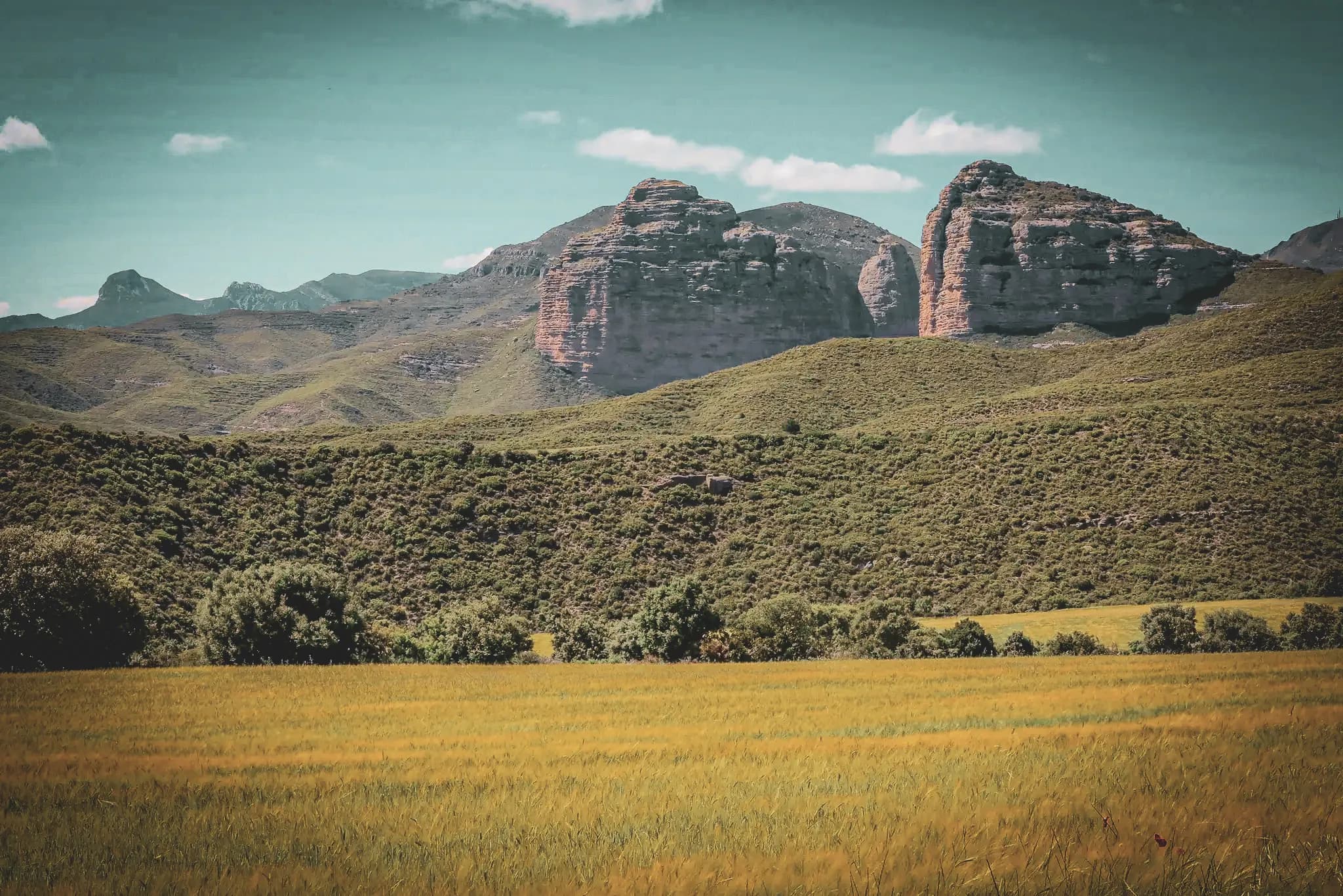The majestic landscapes of the red gorges of the Sierra de Guara, between green hills and rocky peaks.