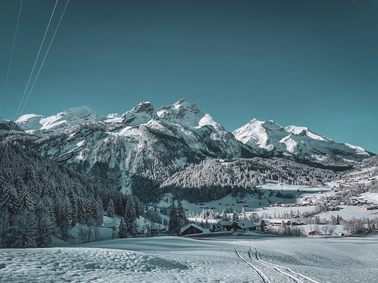 Een besneeuwd Alpenlandschap met majestueuze bergen en azuurblauwe luchten die je uitnodigen om te ontsnappen.