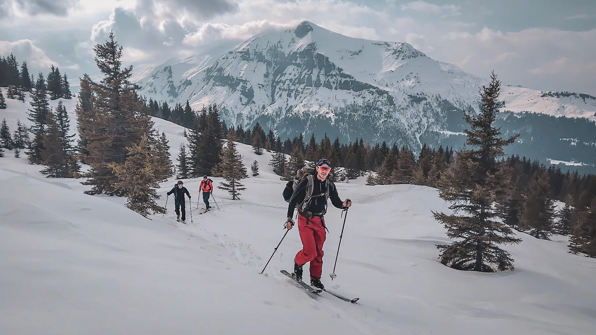 Hikers on skis amid snow-covered landscapes, with the majestic Mont Blanc in the background.