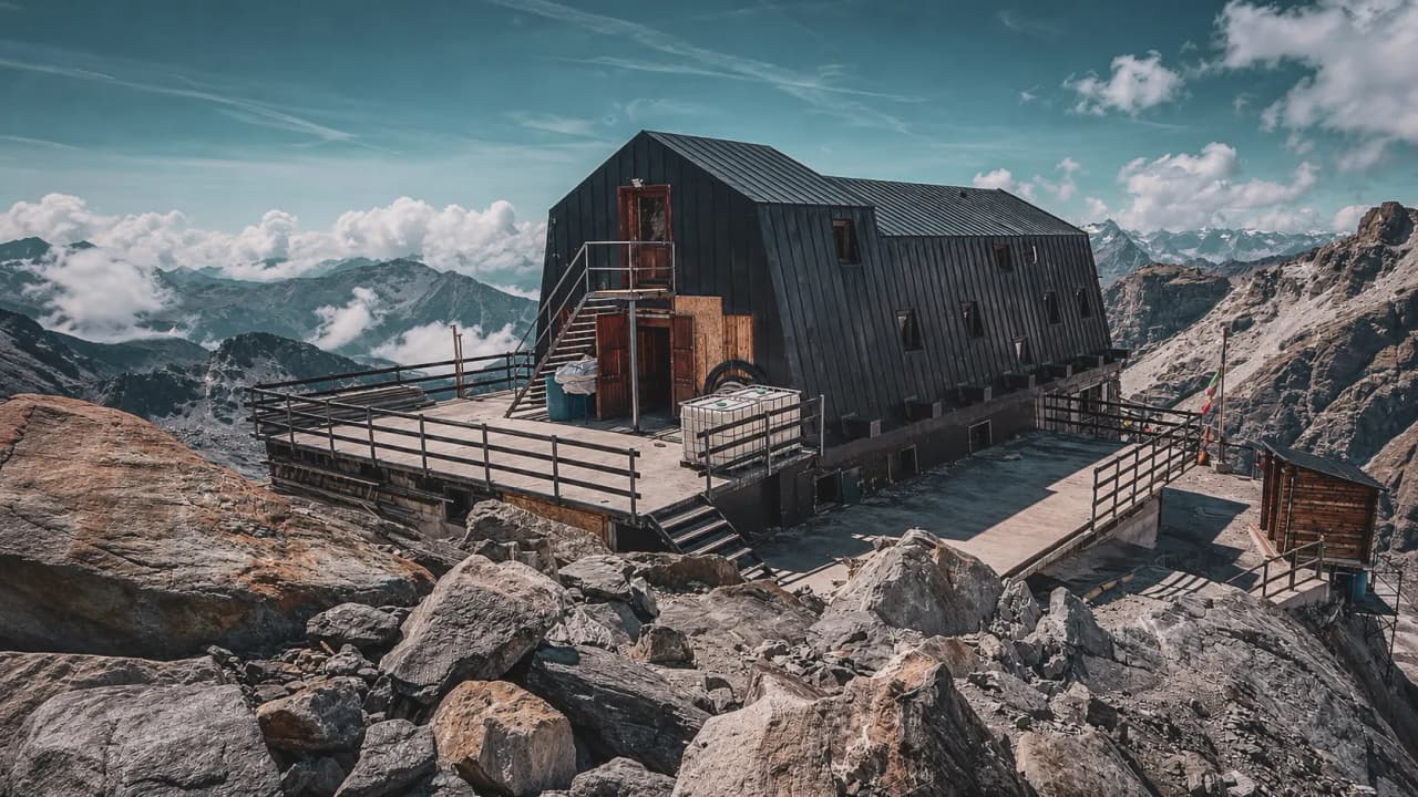 A modern mountain hut, surrounded by majestic mountains and drifting clouds.