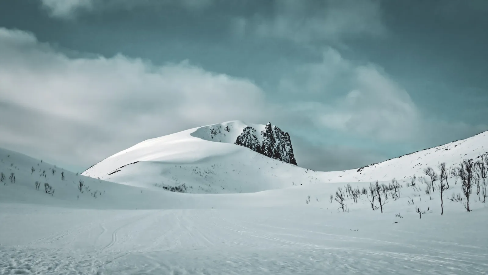 Uitgestrekte besneeuwde landschappen met majestueuze bergen, een uitnodiging tot avontuur in Noorwegen.