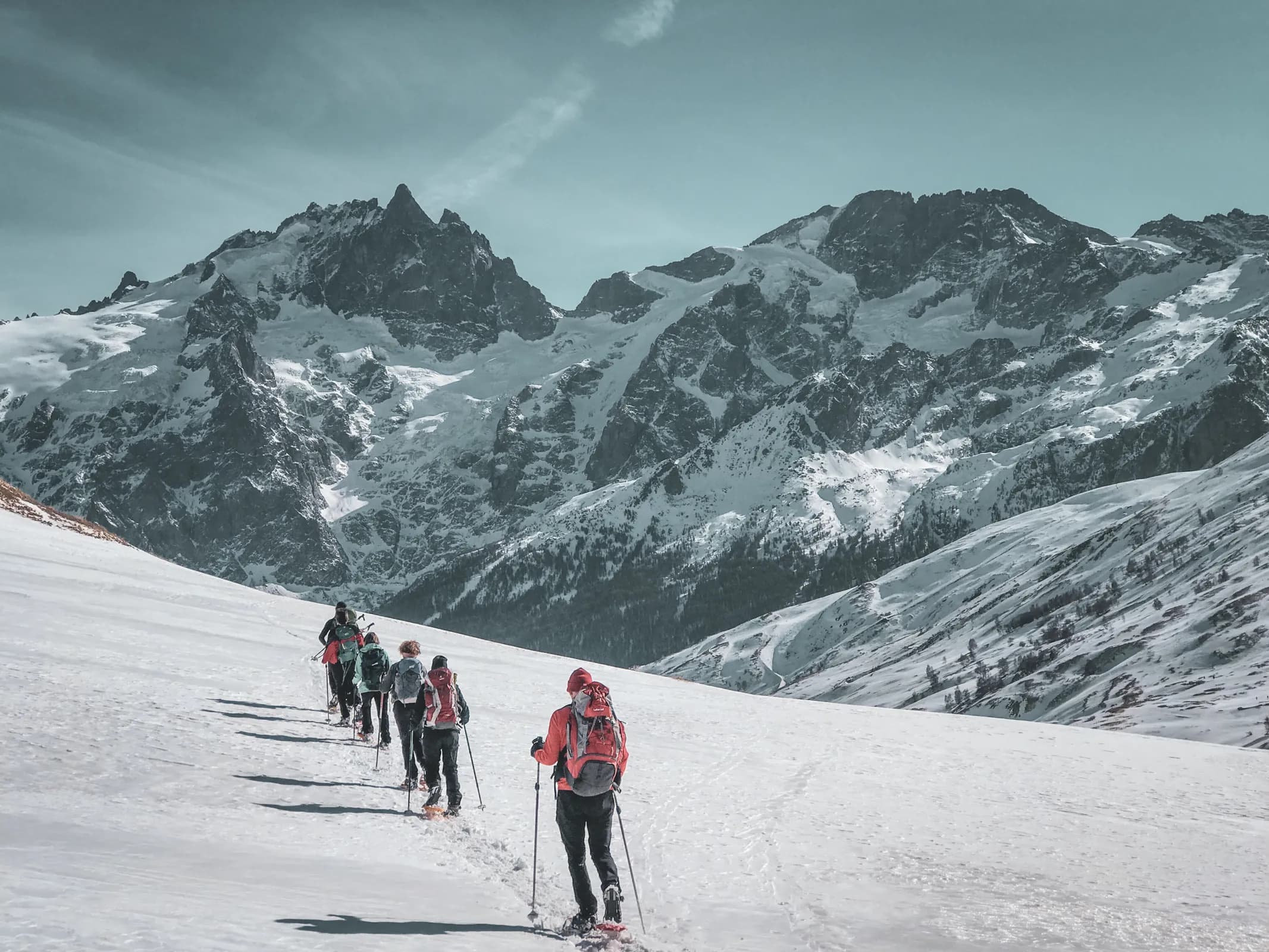 Randonnée en raquettes à neige face aux majestueux glaciers des Écrins, un panorama enchanteur.
