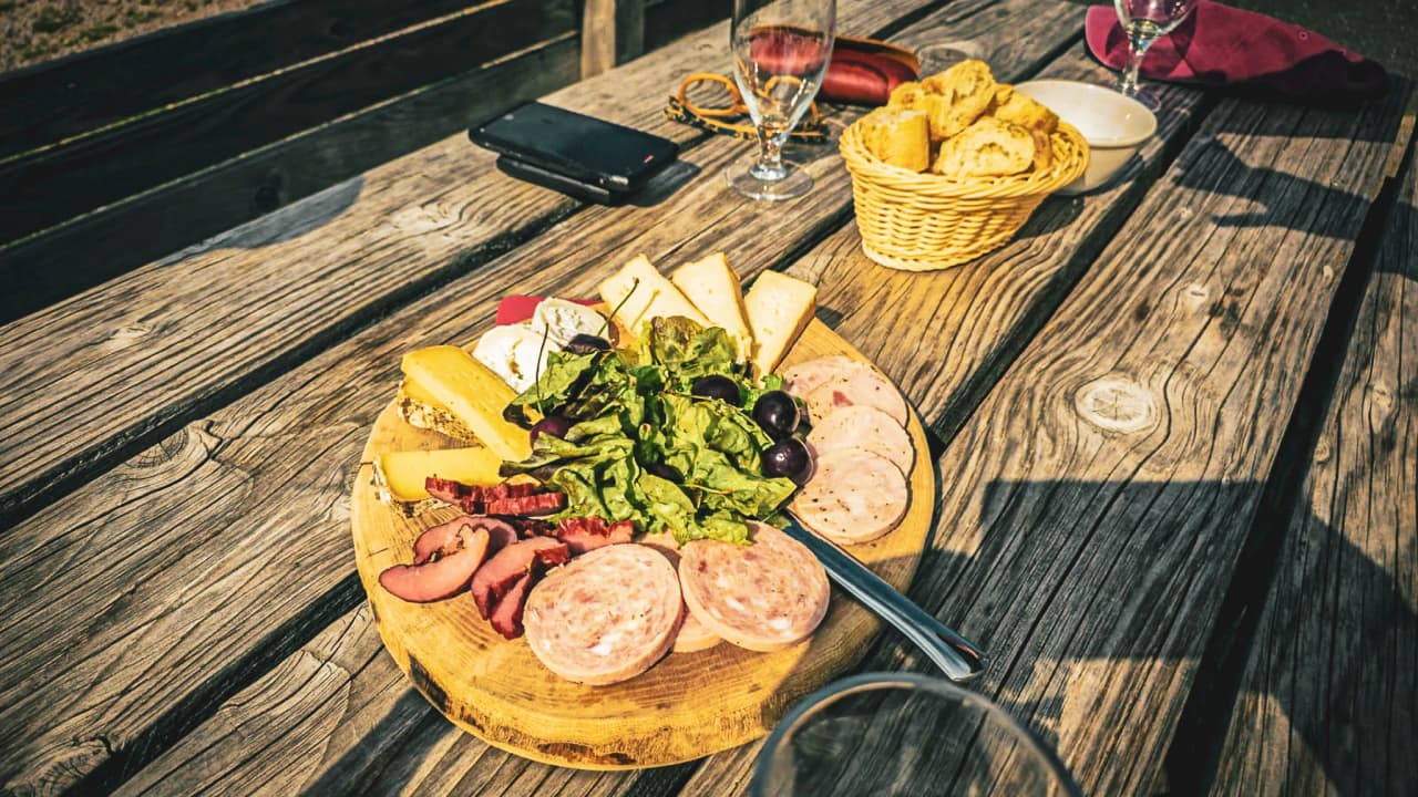 Gourmet platter with charcuterie, cheeses and salad, on a wooden table in the Vosges.
