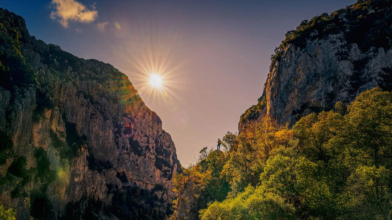Clear skies over the Gorges du Verdon, bright sunshine and majestic cliffs surrounded by greenery.