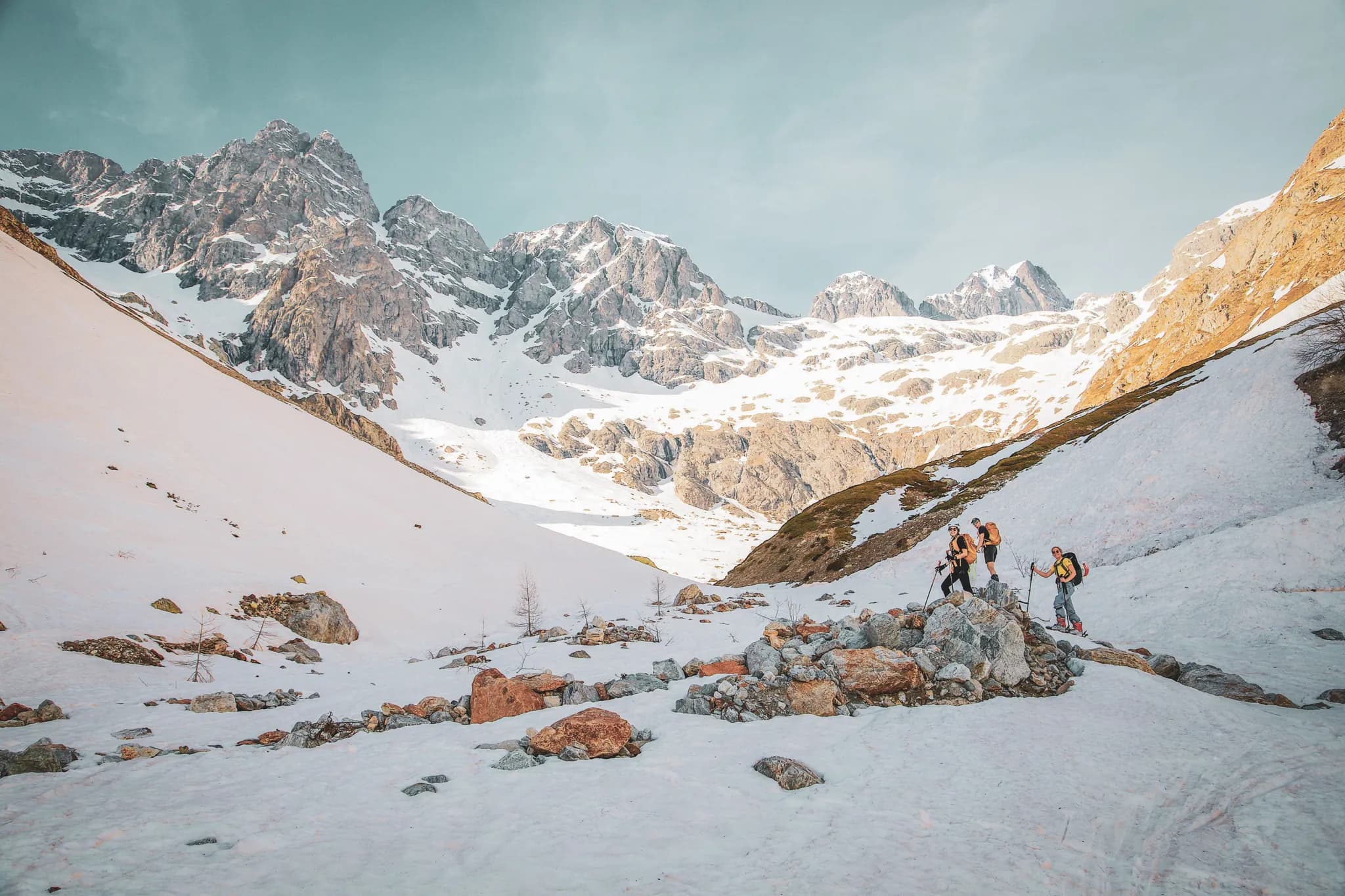 In the midst of an alpine adventure, hikers explore the majestic landscape of the Écrins, between snow and rock.