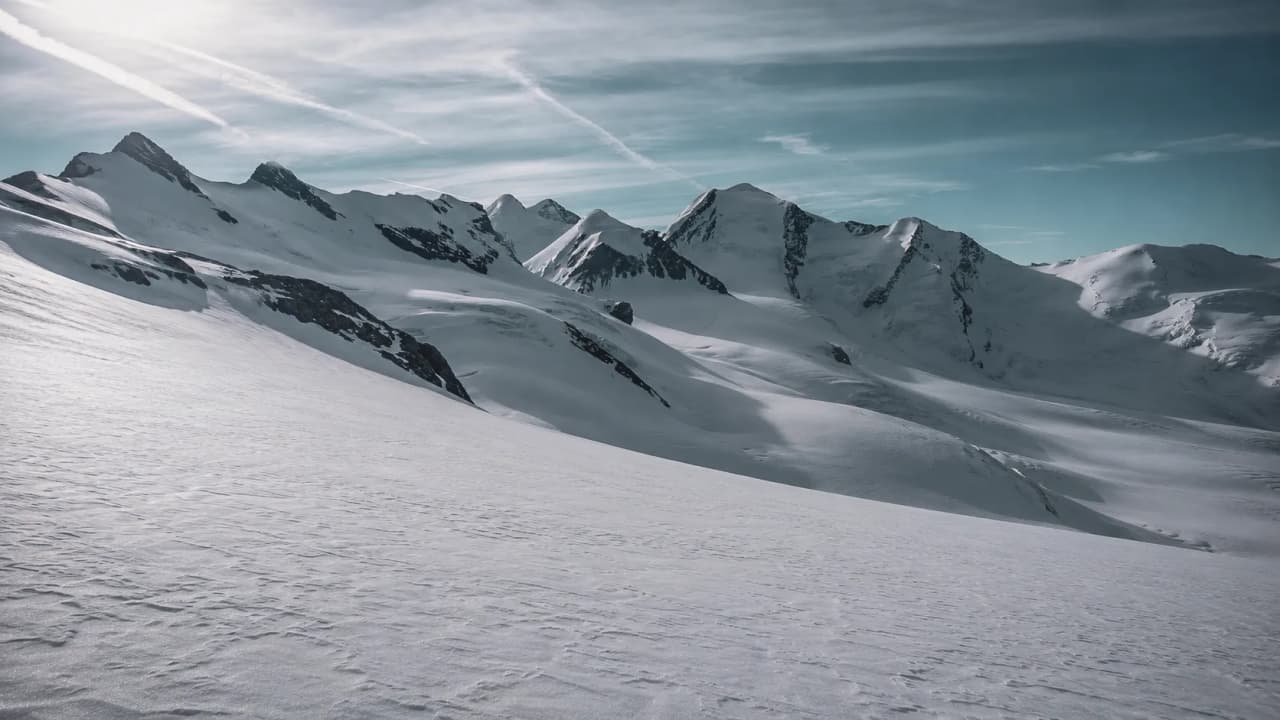 A breathtaking mountainous landscape, blanketed in glistening snow, beckoning you to embark on an alpine adventure.