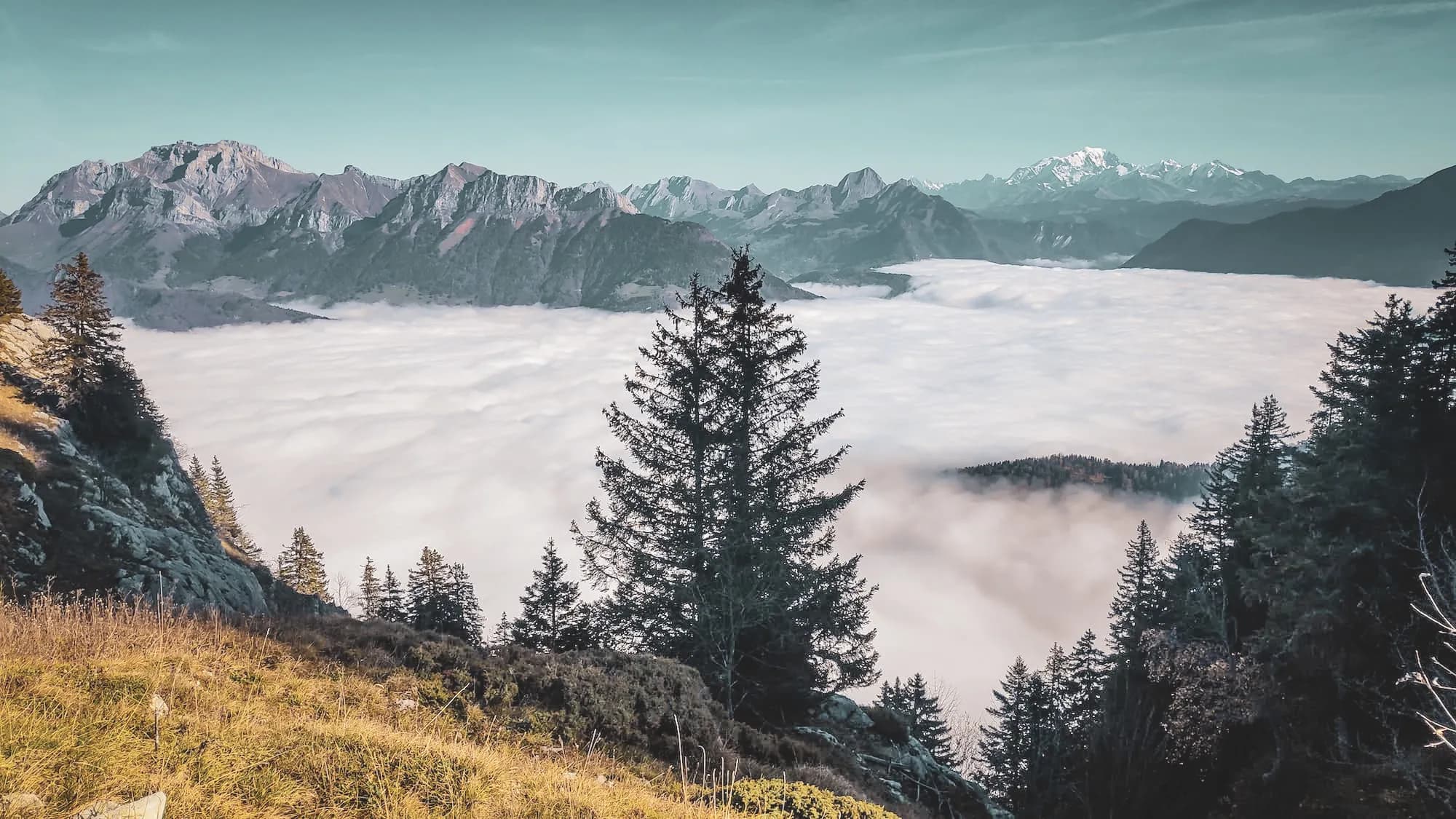 Mountain scenery with majestic peaks rising out of the clouds, an invitation to adventure.