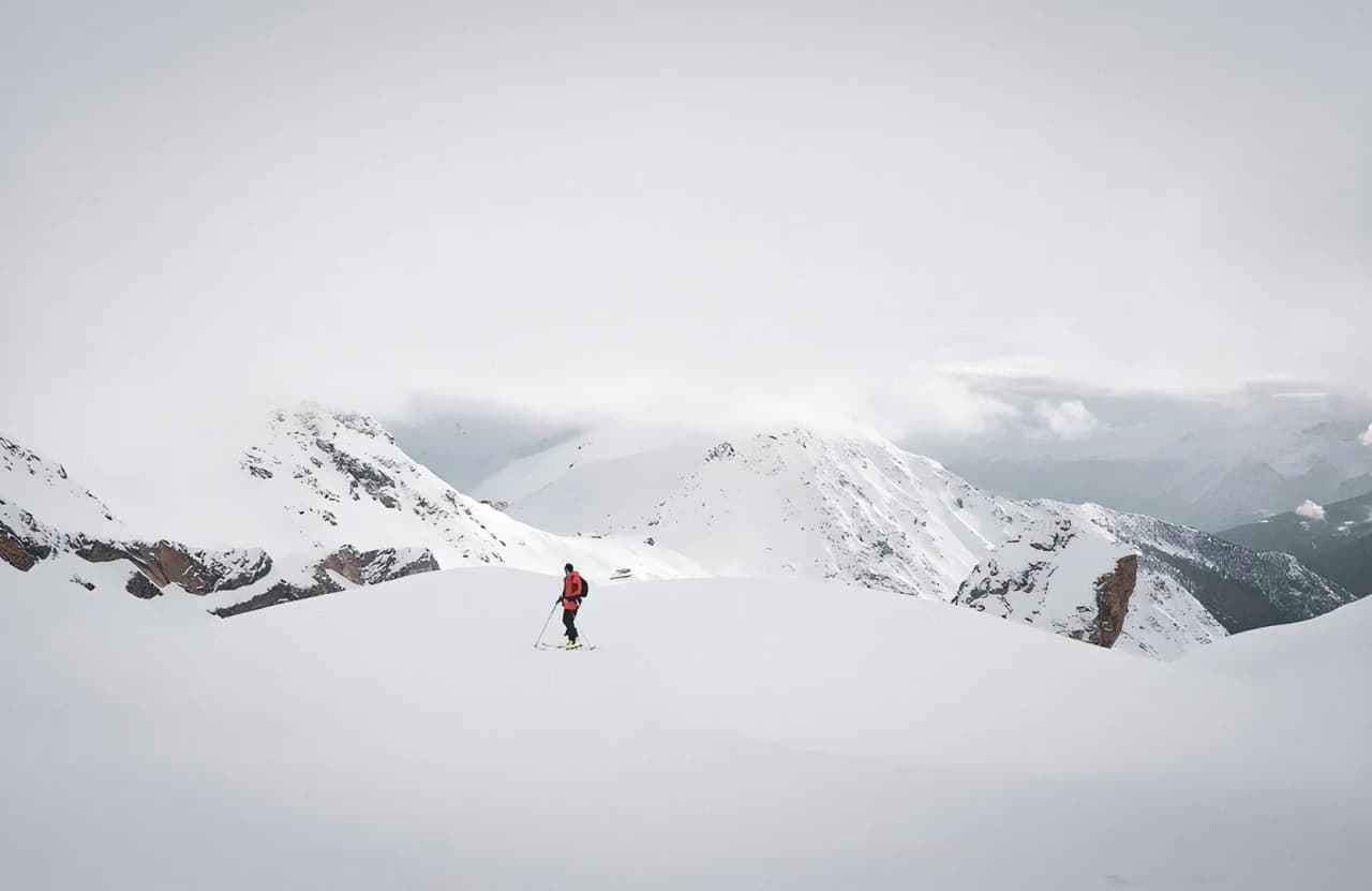 Randonneur dans un paysage enneigé de montagne.