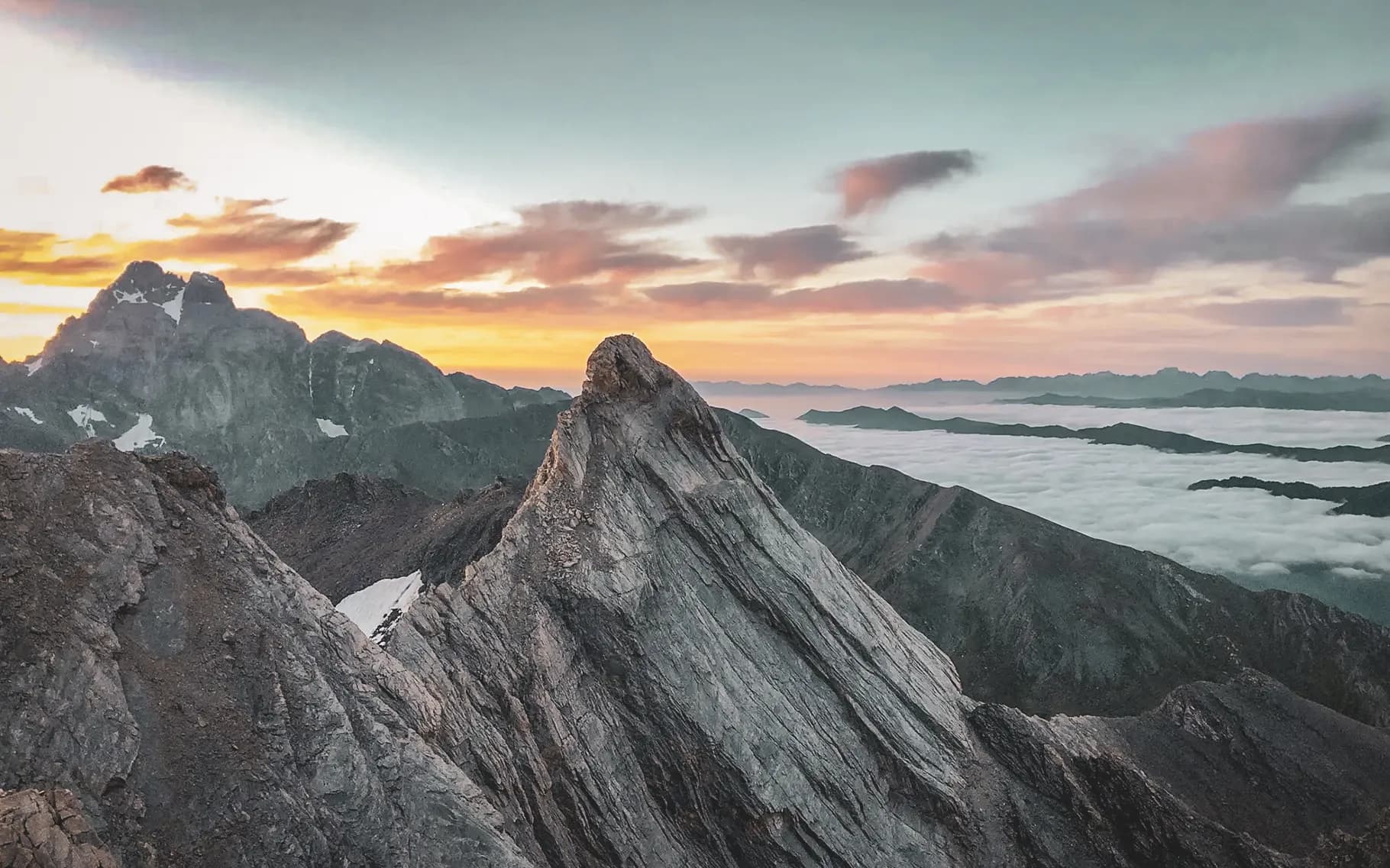 A majestic summit at sunset, overlooking misty valleys. Escape to the heart of nature.