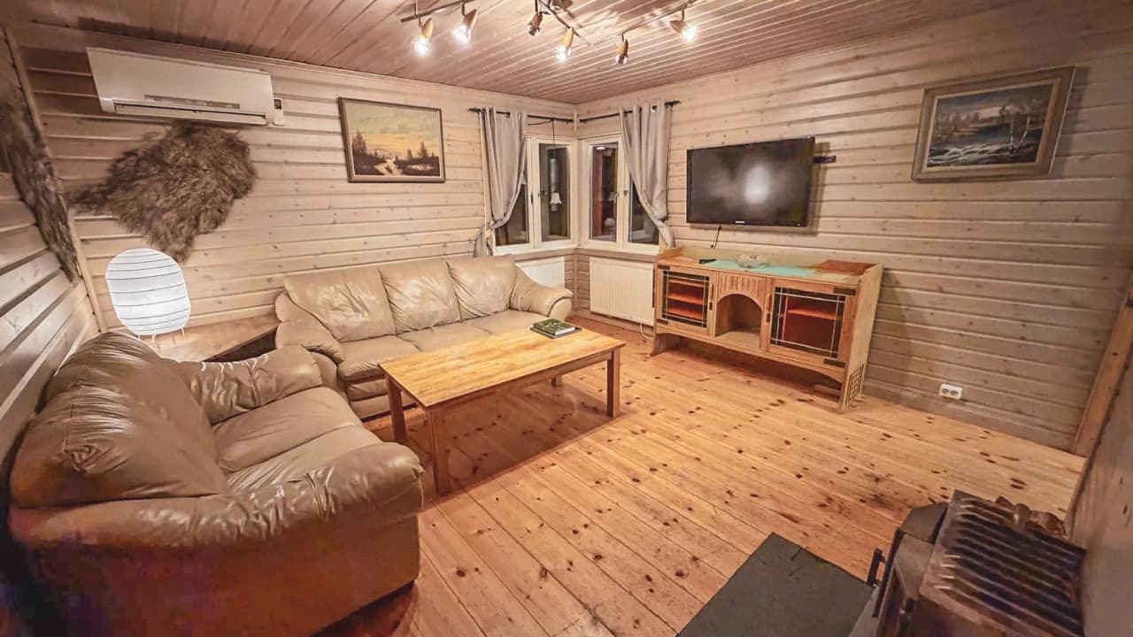 A cosy Lapland chalet living room with comfortable sofas, soft lighting and a welcoming atmosphere.