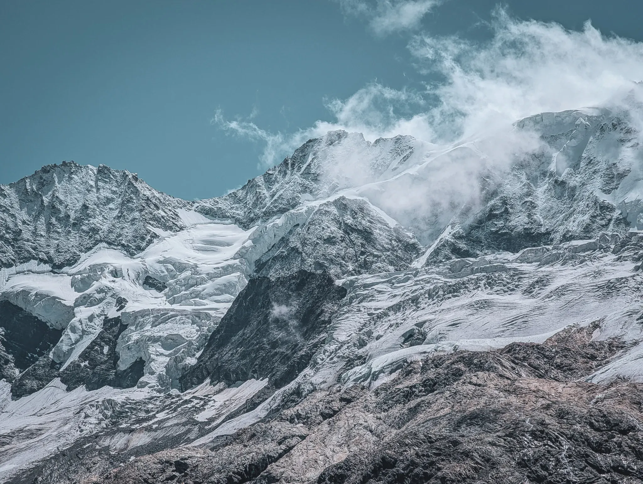Majestic Alpine scenery with glistening glaciers and majestic peaks under a blue sky.