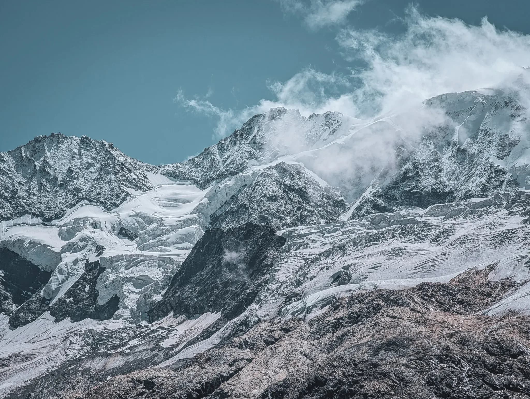 Majestic Alpine scenery with glistening glaciers and majestic peaks under a blue sky.