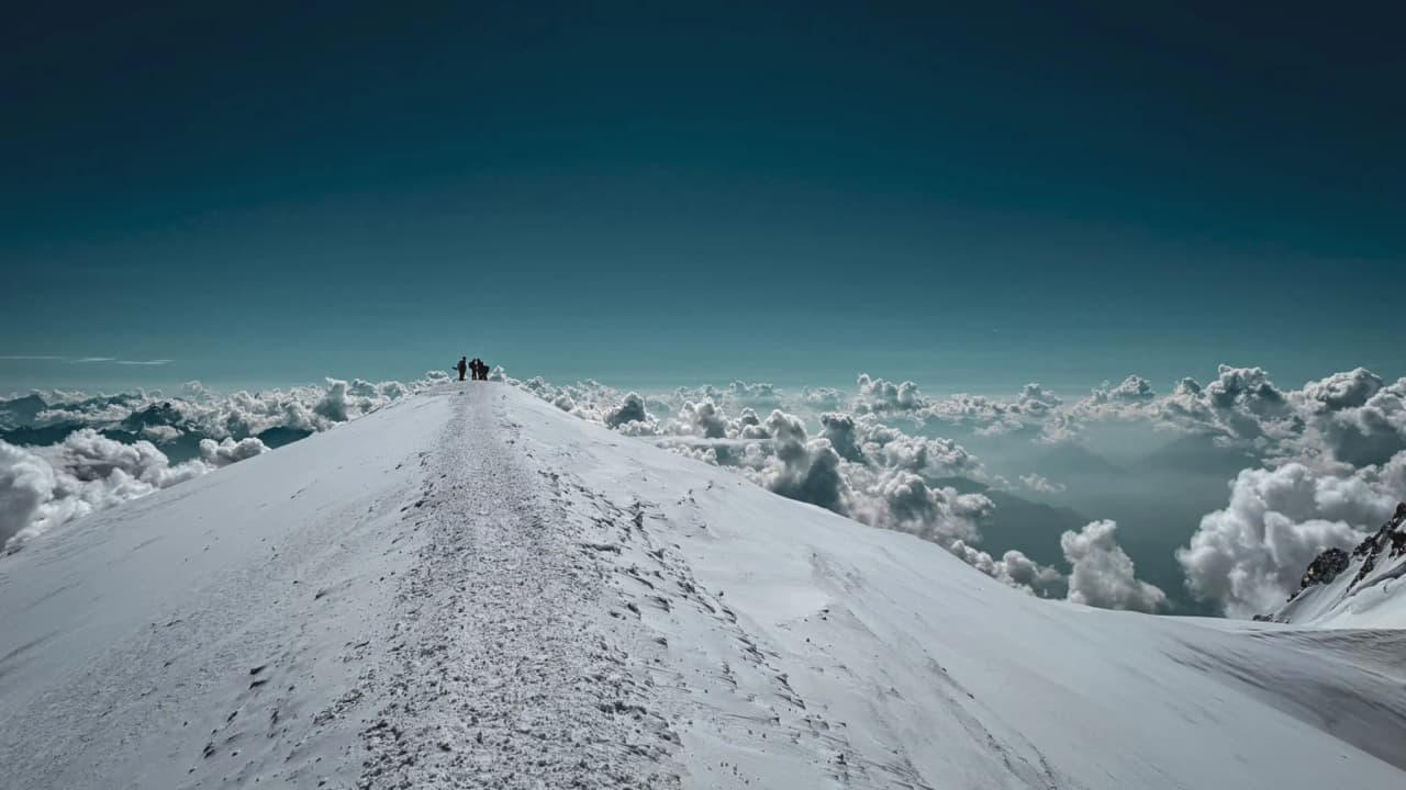 The snow-capped summit of Mont Blanc, towering above the clouds – a majestic adventure awaits.