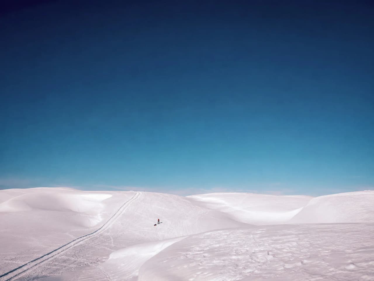 Een besneeuwd landschap met een stralend blauwe lucht, ideaal voor een avontuur op sneeuwschoenen.