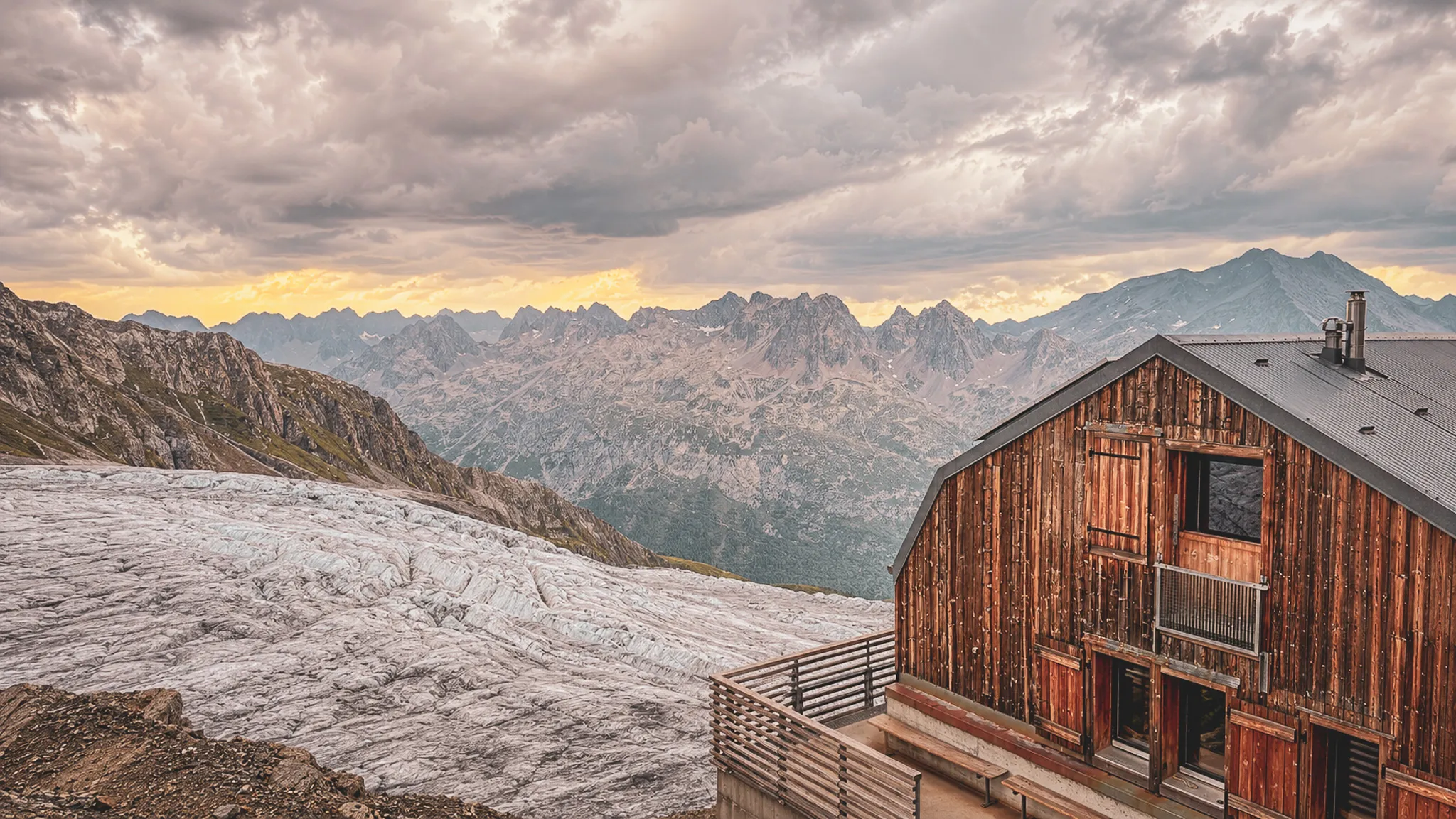 Magnifique paysage alpin avec un chalet en bois surplombant un glacier et des montagnes majestueuses.