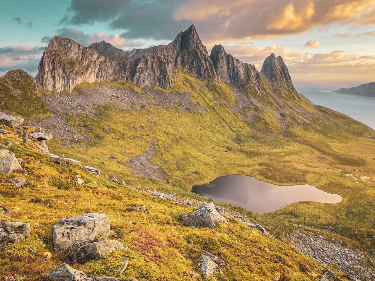 Majestueuze bergtoppen en glinsterende meren op het eiland Senja in de schemering, een uitnodiging voor avontuur.