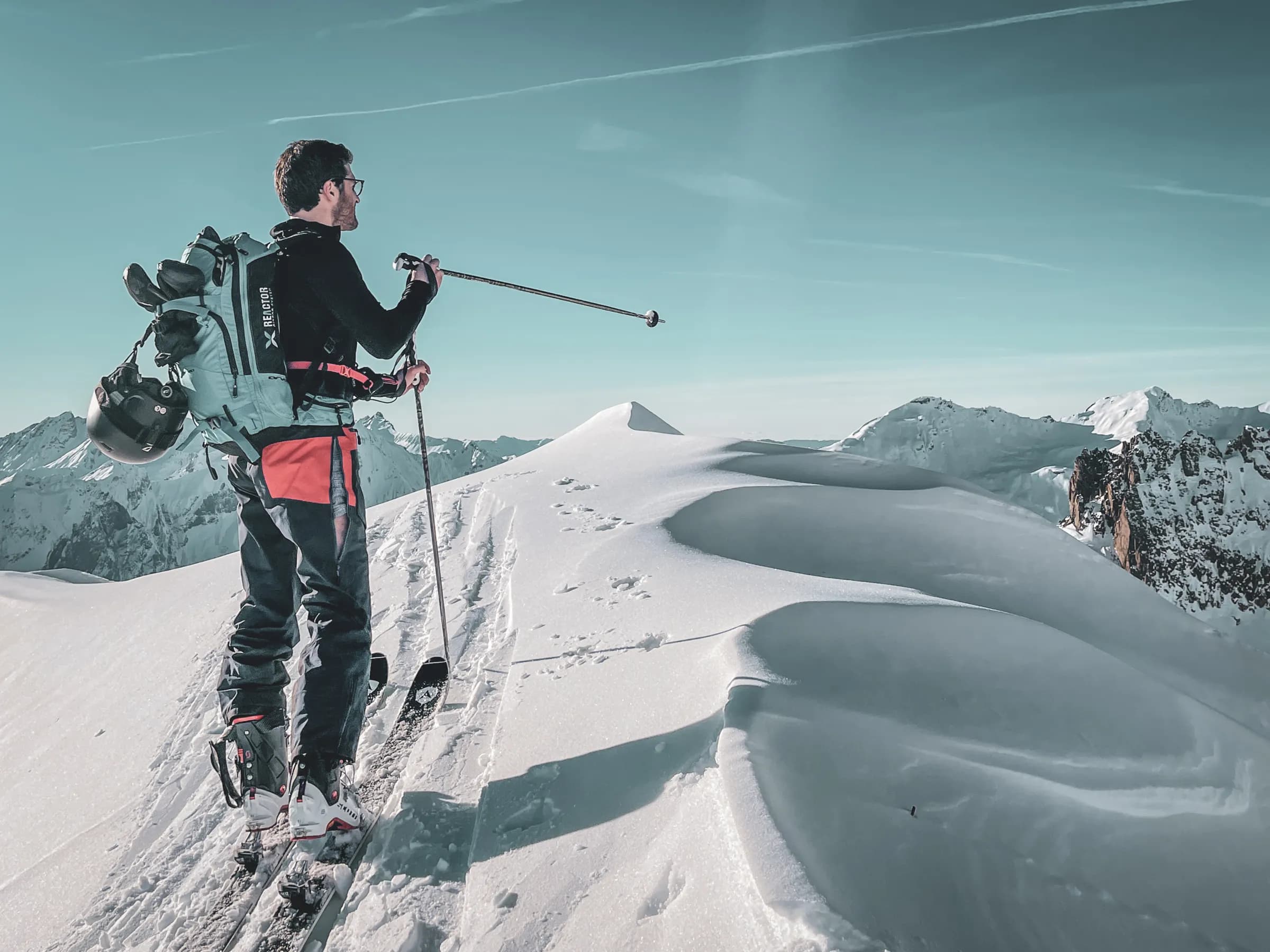 A skier contemplating the majestic snow-capped mountains of the Vanoise, an inspiring adventure.