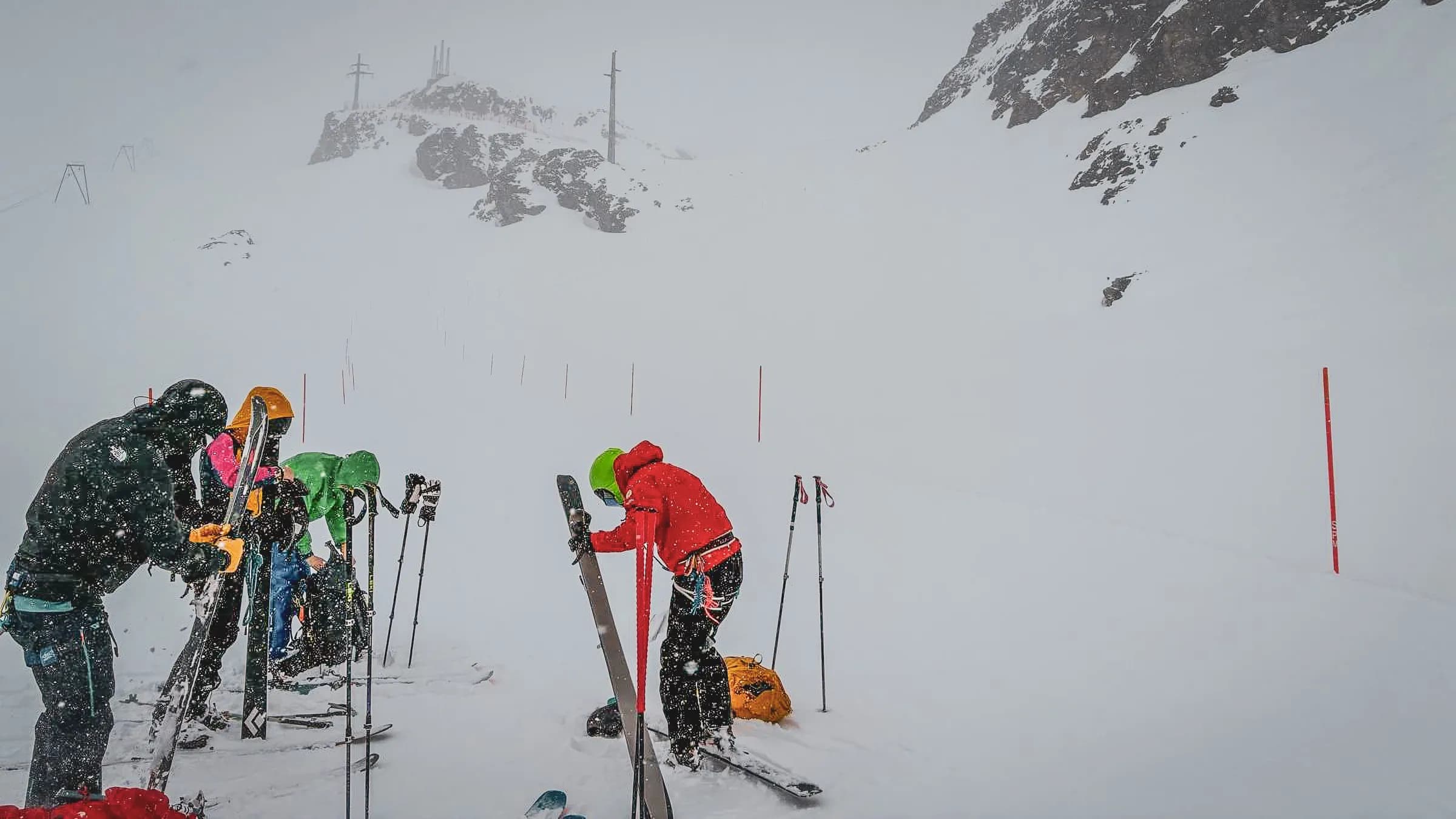 Groupe d'alpinistes en pleine neige sur un glacier, skis en main, prêts pour l'aventure.
