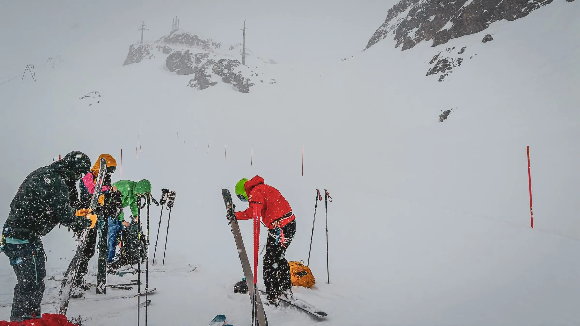 Groupe d'alpinistes en pleine neige sur un glacier, skis en main, prêts pour l'aventure.