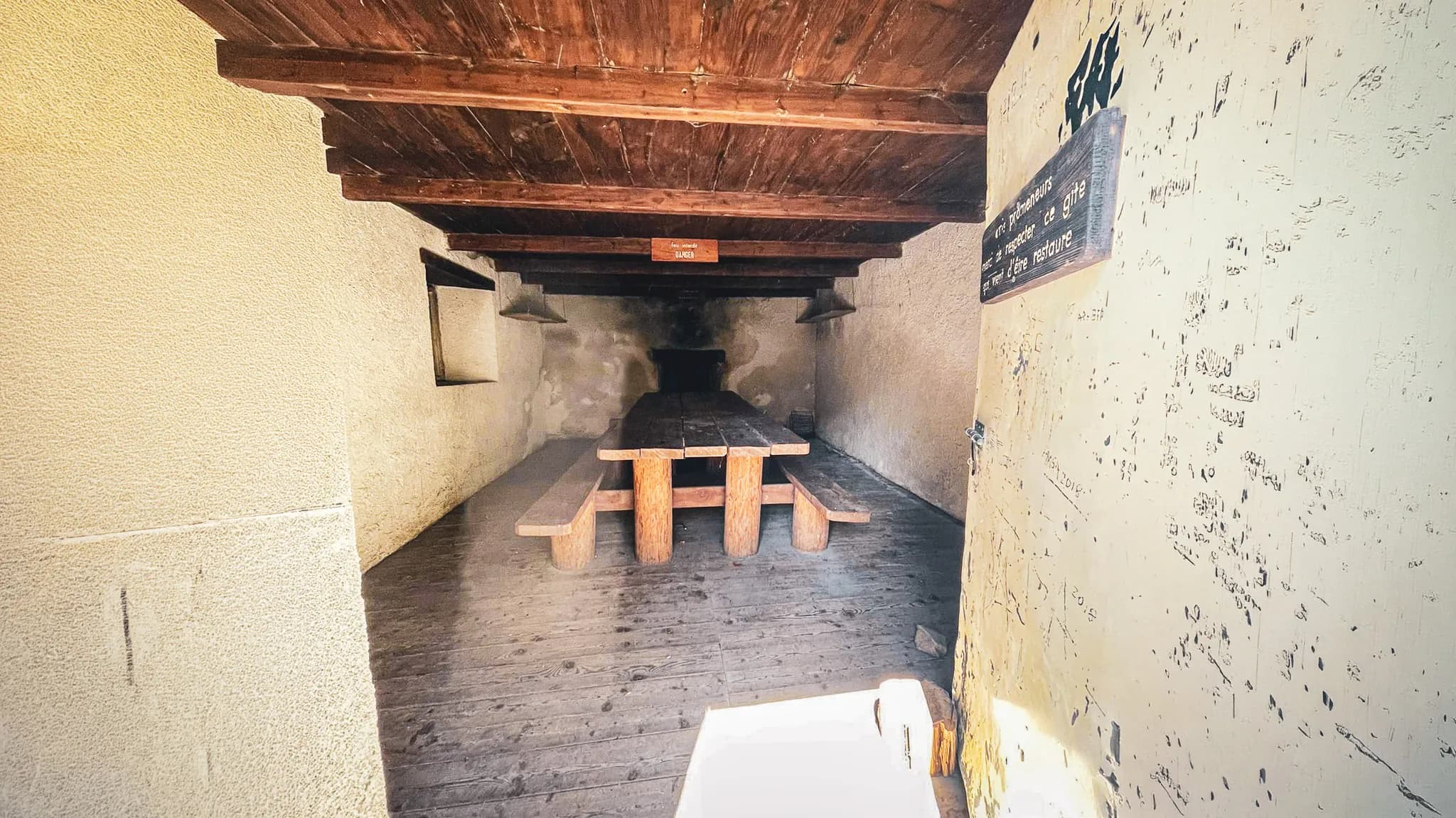 Une table en bois rustique dans un abri montagnard, parfait pour se rassembler après une randonnée.