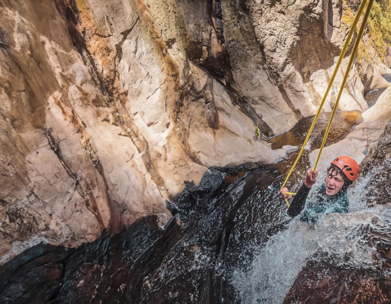 Aventure en canyoning : descente aquatique dans un paysage rocheux et naturel, éclaboussures joyeuses.