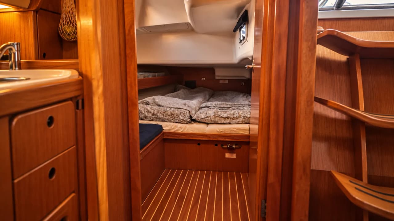 Cabine chaleureuse d'un voilier avec lits confortables, idéale pour des nuits sous les aurores boréales.