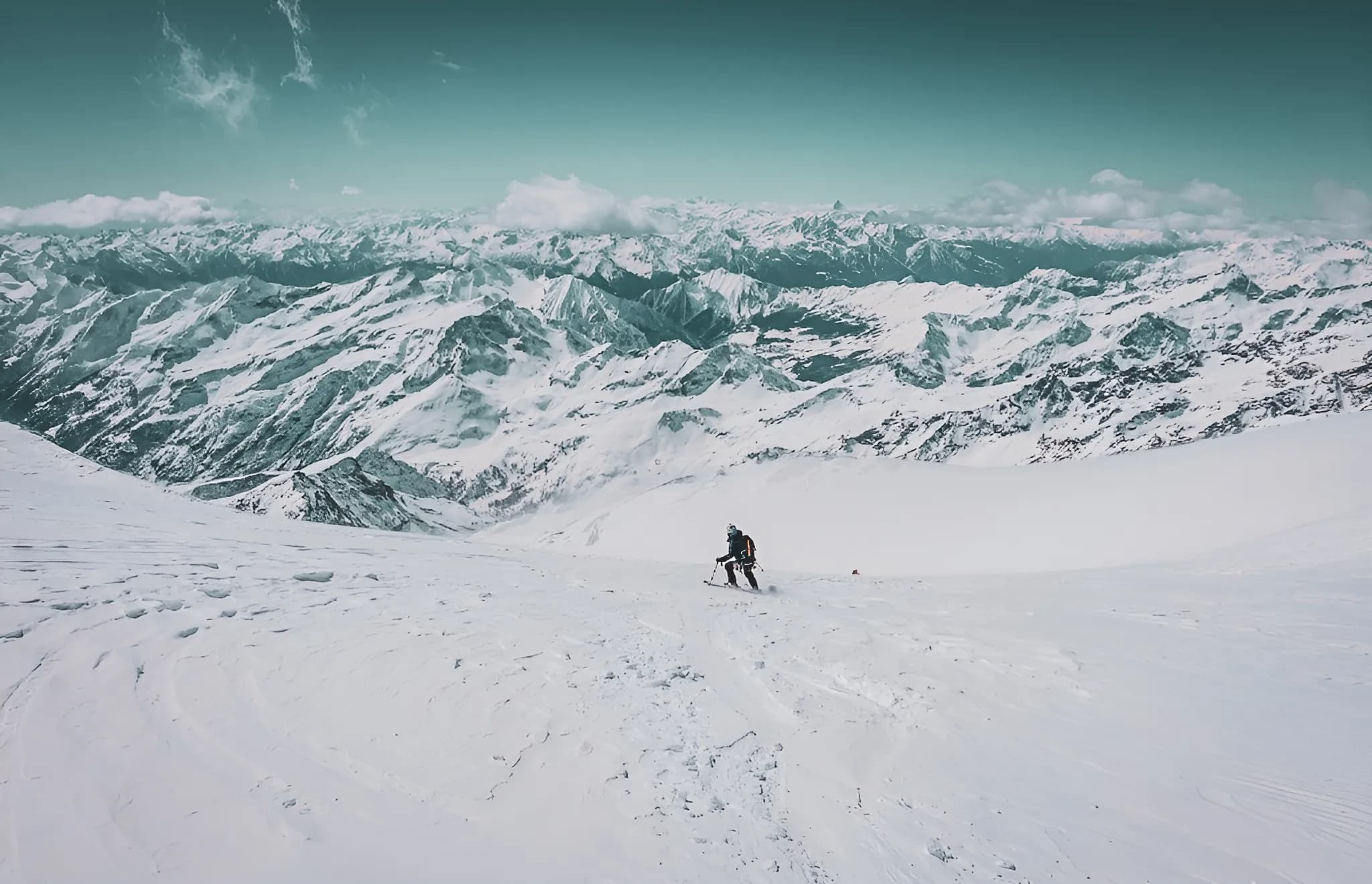 Skieur solitaire sur un glacier, entouré de majestueuses montagnes enneigées. Une aventure alpine.