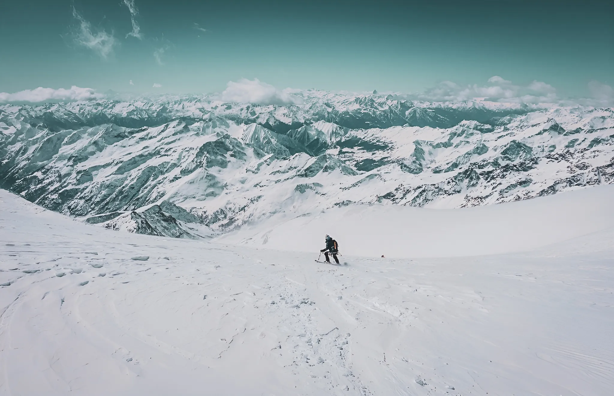 Skieur solitaire sur un glacier, entouré de majestueuses montagnes enneigées. Une aventure alpine.